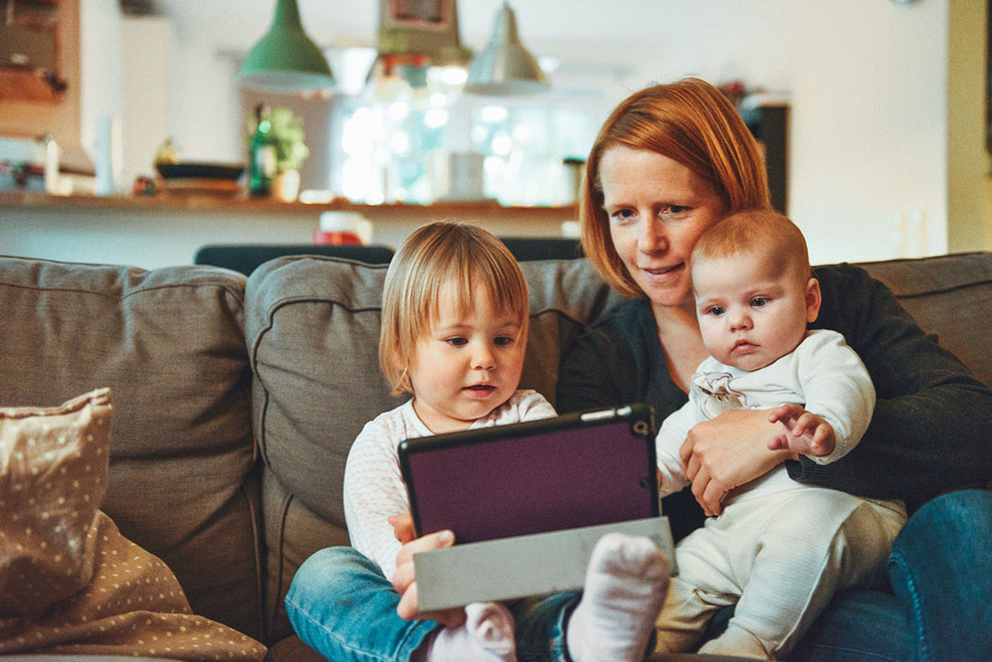 grandma with two grandchildren in front of a tablet