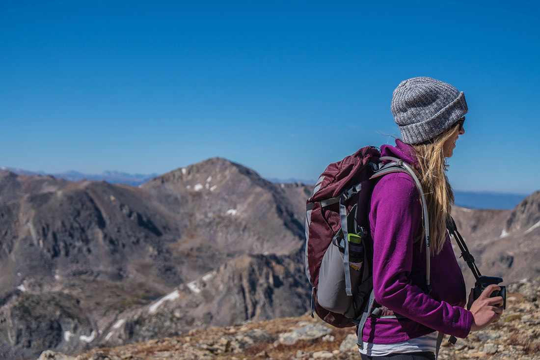 Female solo traveler with a backpack on a mountain